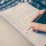 Budget Plan - person writing bucket list on book